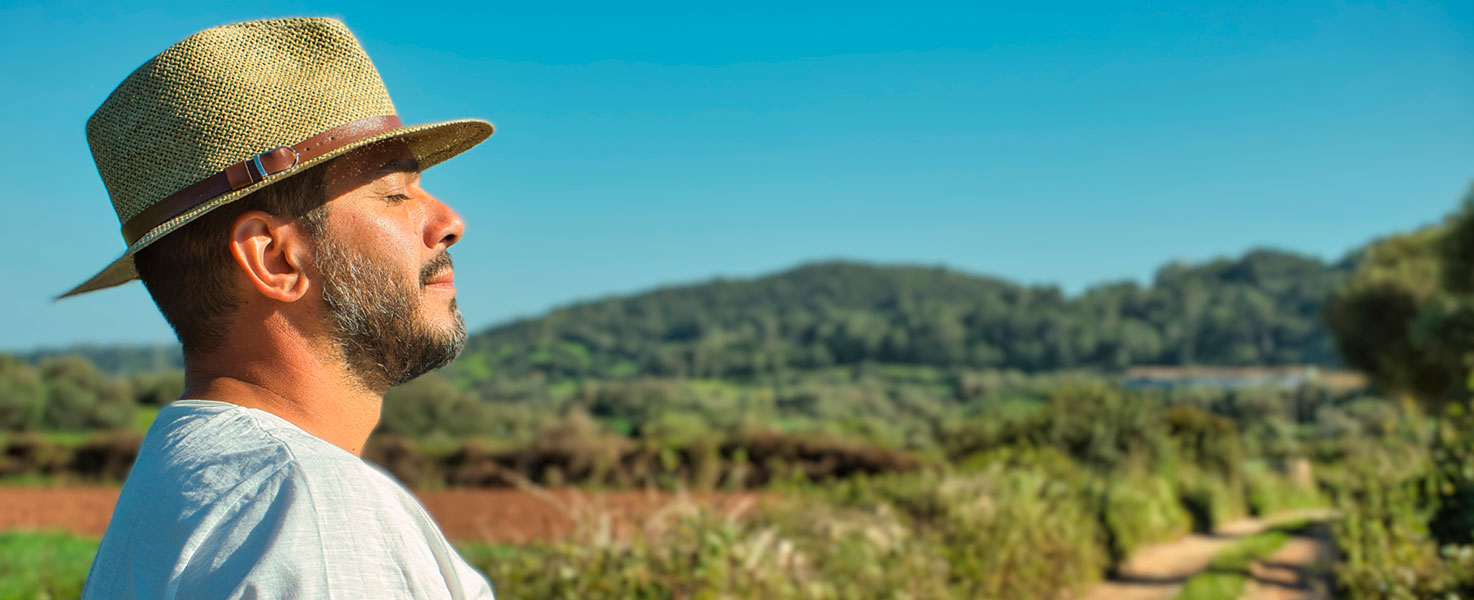 Man closing eyes and standing in a field
